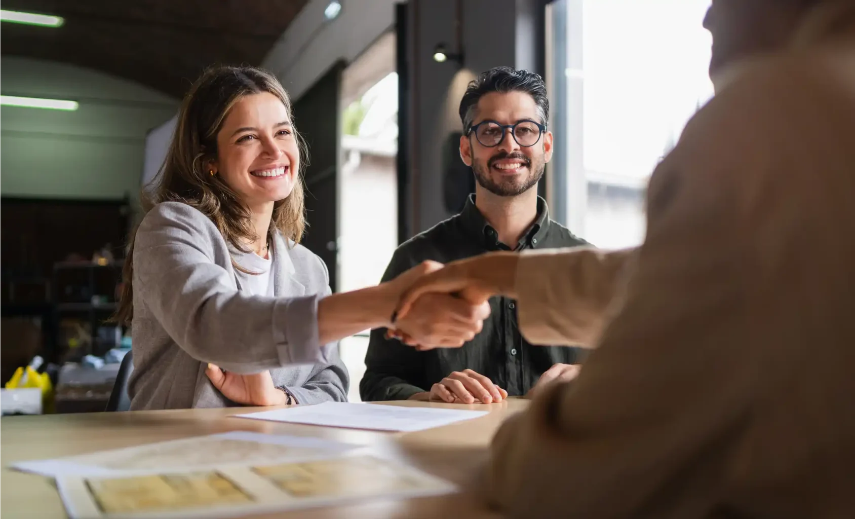 Glückliches Ehepaar bei Beratung zu Fördermitteln