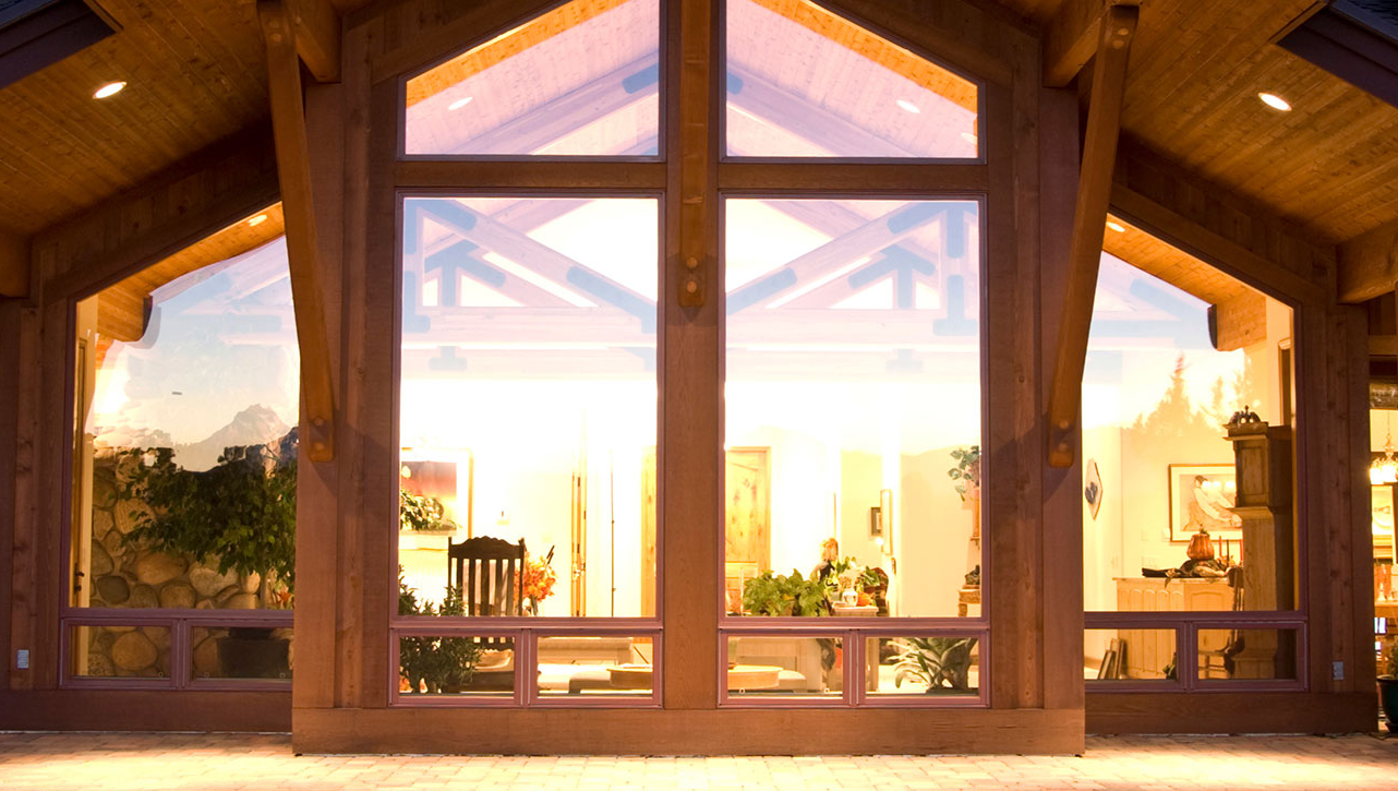 Große und massive Holz-Fenster an einem Holzhaus.