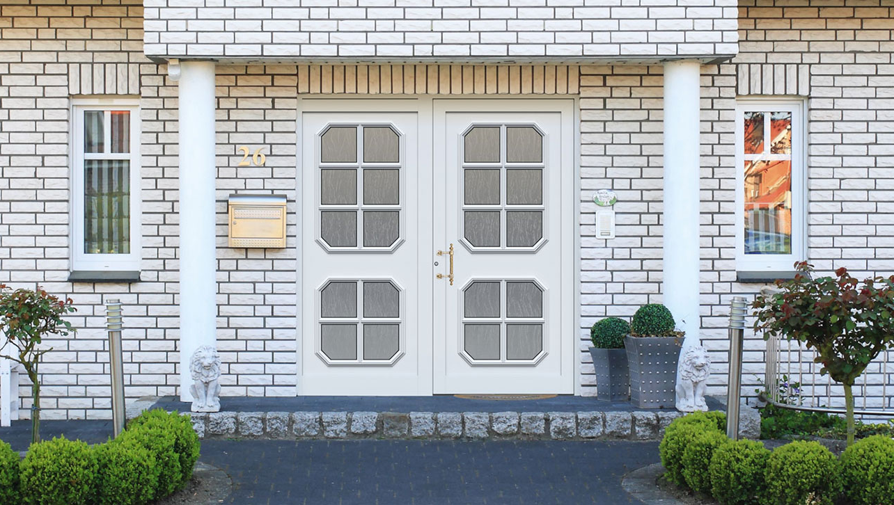 Weißes Backsteinhaus mit Säulen und Kompotherm Rubens EIngangstür