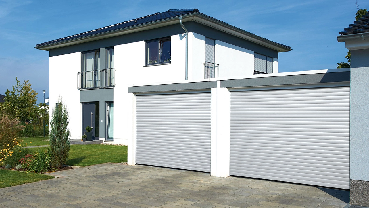 Doppelte Garage mit silberfarbenen Deckenlauftoren bei einem modernen Haus