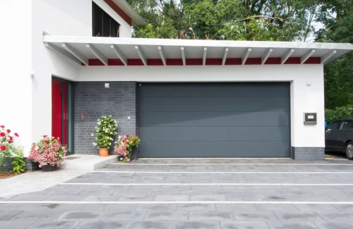 Schiefergraues Garagen-Sektionaltor an einer Garage eines modernen Hauses