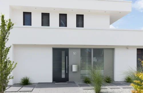 Modernes weißes Haus mit dunkler Haustür mit Glaseinsätzen