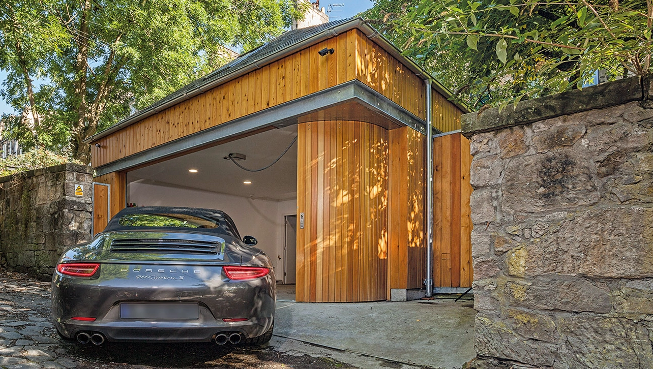 Holzverkleidete Garage mit geöffnetem Steinau Rundlauftor aus Holz