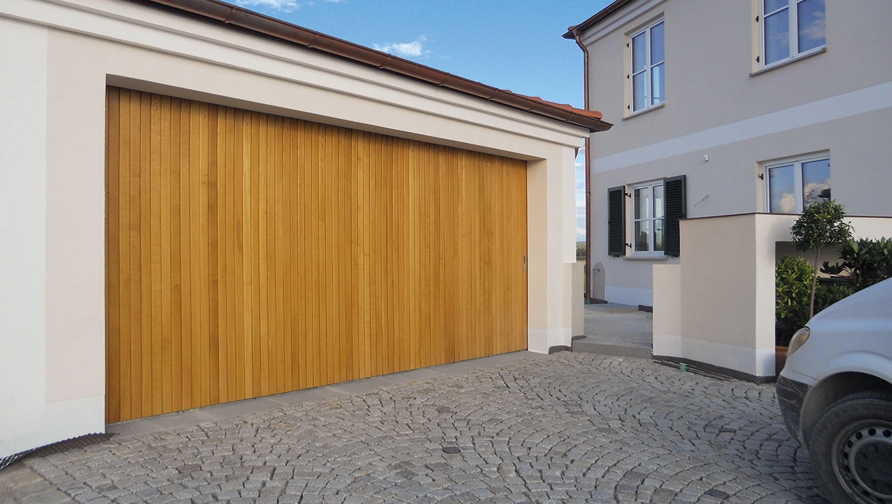 Steinau Seiten-Sektionaltor mit Holzlamellen an einer freistehenden Garage