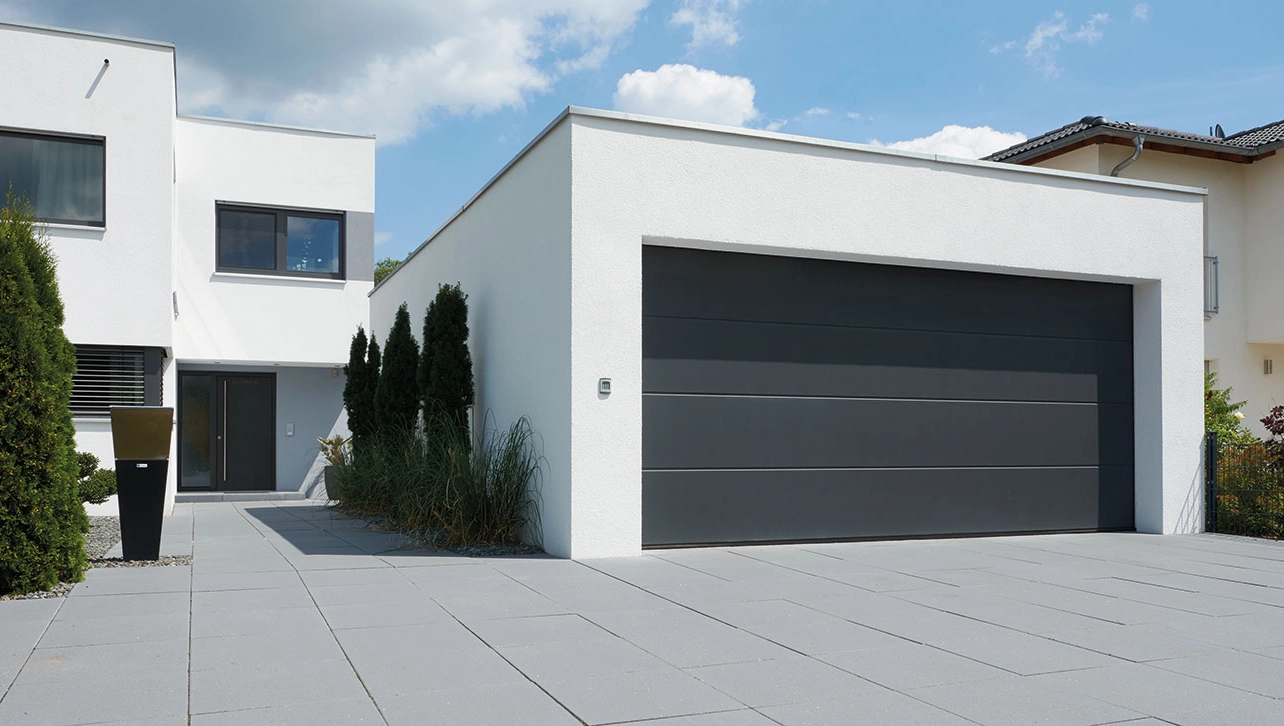 Freistehende Garage mit Steinau Sektionaltor in dunklem Grau