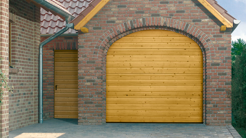 Steinau Sektionaltor aus Holz mit Rundbogenöffnung an kleiner Garage